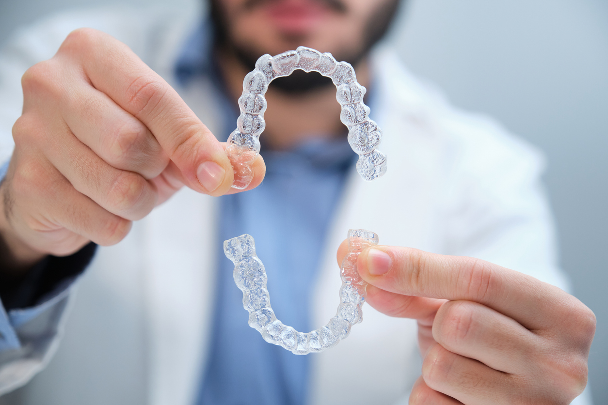 Close up of two clear aligners being held by an orthodontist